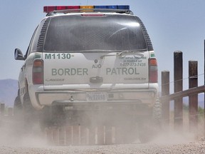 FILE - In this May 26, 2006 file photo, a U.S. Border Patrol agent patrols the international border separating Sonoyta, Mexico, right of fence, and Lukeville, Ariz., in Organ Pipe Cactus National Monument. Smugglers in recent weeks have been abandoning large groups of Guatemalan and other Central American migrants in the desert near Arizona's boundary with Mexico, alarming Border Patrol officials who say the trend is putting hundreds of children and adults at risk.