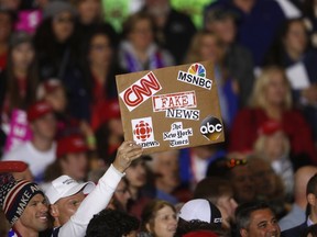 FILE - In this April 28, 2018 file photo, an audience member holds a 'fake news' sign during a President Donald Trump rally in Washington Township, Mich. Local members of the media says they've noticed more hostility from the public since Trump began his attacks on 'fake news.' Trade groups are spreading safety tips because of the incidents.