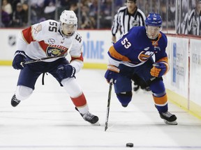 Florida Panthers' Bogdan Kiselevich (55) and New York Islanders' Casey Cizikas (53) skate for the puck during the second period of an NHL hockey game Wednesday, Oct. 24, 2018, in New York.