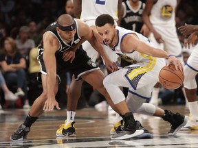 Golden State Warriors' Stephen Curry, right, protects the ball from Brooklyn Nets' Jared Dudley (6) during the second half of an NBA basketball game Sunday, Oct. 28, 2018, in New York.