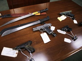 FILE - This Jan. 29, 2016, file photo shows weapons on display at the U.S. Attorney's office following the arrests of gang members in Boston. Nearly three years after the nation's largest single takedown of MS-13 gang members, residents of strongly Central American communities in the Boston area say the streets are noticeably quieter.