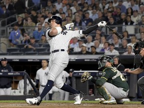 New York Yankees' Aaron Judge follows through on a two-run home run against the Oakland Athletics during the first inning of the American League wildcard playoff baseball game, Wednesday, Oct. 3, 2018, in new York