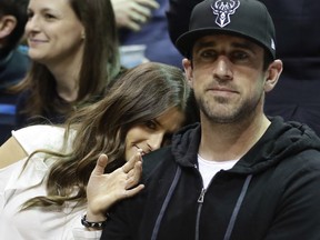 FILE - In this April 20, 2018 file photo Danica Patrick and Green Bay Packers' Aaron Rodgers watch during the first half of Game 3 of an NBA basketball first-round playoff series between the Milwaukee Bucks and the Boston Celtics in Milwaukee. Patrick encountered some resistance from Rodgers when she wanted to set up a woman cave in the house they share in Green Bay, Wisconsin. The retired racecar driver proposed converting a bedroom into her own space. She says she got "shut down" even though Rodgers has a man cave in the house.