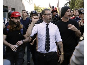 FILE - In this April 27, 2017 file photo, Gavin McInnes, center, founder of the far-right group Proud Boys, is surrounded by supporters after speaking at a rally in Berkeley, Calif. McInnes and his Proud Boys group have been banned from Facebook and Instagram because of policies prohibiting hate groups.
