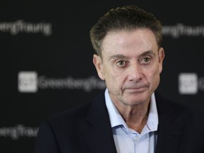 FILE- In this Feb. 21, 2018 file photo, former Louisville basketball Hall of Fame coach Rick Pitino talks to reporters during a news conference in New York. A recruiter, a coach and a former Adidas executive are scheduled to go on trial in New York in a criminal case that exposed corruption in several top U.S. college basketball programs. It also led to the firing of Pitino and sidelined the playing career of standout recruit Brian Bowen Jr.