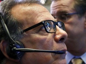 The NYSE and Yeti logos are reflected in the glasses of trader Sal Suarino as he works on the floor of the New York Stock Exchange, Thursday, Oct. 25, 2018. Strong results from major companies including Microsoft, Visa and Comcast are sending U.S. stocks higher Thursday morning as the market found its footing after three weeks of steep declines.