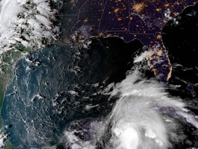 This satellite image provided by the National Oceanic and Atmospheric Administration shows a view of Tropical Storm Michael, lower right, churning as it heads toward the Florida Panhandle, Sunday, Oct. 7, 2018, at 6:52 p.m. Eastern Time. (NOAA via AP)