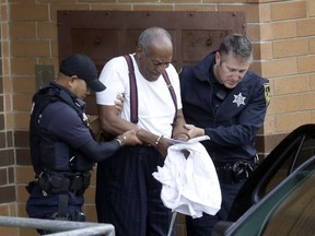 FILE - In a Tuesday Sept. 25, 2018 file photo, Bill Cosby is escorted out of the Montgomery County Correctional Facility, in Eagleville, Pa., following his sentencing to three-to-10-year prison sentence for sexual assault. Cosby's lawyers want a court to overturn the actor's conviction and three- to 10-year sentence in his Pennsylvania sex assault case because of what they call a string of trial errors. The defense motion argues that trial Judge Steven O'Neill erred in declaring Cosby a sexually violent predator who should be imprisoned to protect the community.