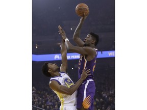 Phoenix Suns center Deandre Ayton, right, shoots against Golden State Warriors center Damian Jones during the first half of an NBA basketball game in Oakland, Calif., Monday, Oct. 22, 2018.