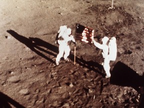 In this July 20, 1969 file photo provided by NASA shows Apollo 11 astronauts Neil Armstrong and Edwin E. "Buzz" Aldrin, the first men to land on the moon, plant the U.S. flag on the lunar surface.