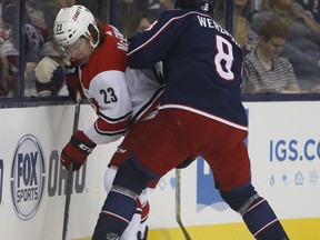 Carolina Hurricanes' Brock McGinn, left, controls the puck as Columbus Blue Jackets' Zach Werenski defends during the first period of an NHL hockey game Friday, Oct. 5, 2018, in Columbus, Ohio.