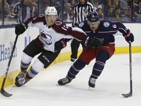 Colorado Avalanche's Sheldon Dries, left, and Columbus Blue Jackets' Adam Clendening chase a loose puck during the first period of an NHL hockey game Tuesday, Oct. 9, 2018, in Columbus, Ohio.