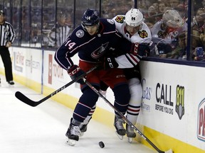 Columbus Blue Jackets defenseman Dean Kukan, left, of Switzerland, works against Chicago Blackhawks forward David Kampf, of the Czech Republic, during the first period of an NHL hockey game in Columbus, Ohio, Saturday, Oct. 20, 2018.