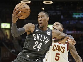 Brooklyn Nets' Rondae Hollis-Jefferson (24) grabs a pass against Cleveland Cavaliers' JR Smith (5) in the first half of an NBA basketball game, Wednesday, Oct. 24, 2018, in Cleveland.