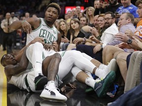 Boston Celtics' Marcus Smart is held back by teammates during a scuffle in the first half of an NBA preseason basketball game against the Cleveland Cavaliers, Saturday, Oct. 6, 2018, in Cleveland. Smart was ejected from the game.