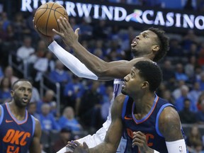 Sacramento Kings guard Buddy Hield, center, shoots between Oklahoma City Thunder forward Patrick Patterson (54) and forward Paul George, right, in the first half of an NBA basketball game in Oklahoma City, Sunday, Oct. 21, 2018.