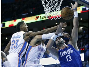 Los Angeles Clippers center Marcin Gortat (13) is fouled by Oklahoma City Thunder guard Russell Westbrook (0) as he shoots in the first half of an NBA basketball game in Oklahoma City, Tuesday, Oct. 30, 2018. Thunder guard Terrance Ferguson (23) is at left.