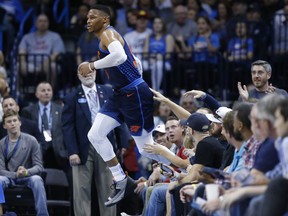 Oklahoma City Thunder guard Russell Westbrook jumps back to the court after chasing a ball out of bounds and into the crowd in the first half of an NBA basketball game against the Sacramento Kings in Oklahoma City, Sunday, Oct. 21, 2018.