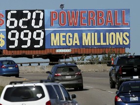 In this Monday, Oct. 22, 2018 photo, drivers on the Broken Arrow Expressway pass a sign with the Powerball and Mega Millions jackpot numbers as they drive toward downtown Tulsa, Okla., Monday, October 22, 2018.