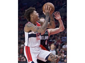 Washington Wizards forward Kelly Oubre Jr., left, shoots over Portland Trail Blazers guard Nik Stauskas during the first half of an NBA basketball game in Portland, Ore., Monday, Oct. 22, 2018.