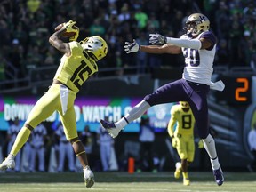 Oregon cornerback Deommodore Lenoir (15), intercepts a pass intended for Washington wide receiver Ty Jones (20), on Washington's first drive during a NCAA college football game in Eugene, Ore., Saturday, Oct. 13, 2018. The play set up an Oregon field goal.