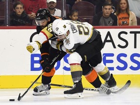 Vegas Golden Knights' William Carrier, right, holds onto Philadelphia Flyers' Radko Gudas as they battle for the puck during the first period of an NHL hockey game, Saturday, Oct. 13, 2018, in Philadelphia.