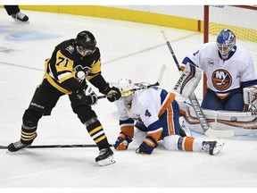 Pittsburgh Penguins center Evgeni Malkin (71) beats New York Islanders defenseman Thomas Hickey (4) and goaltender Thomas Greiss (1) during the third period of an NHL hockey game in Pittsburgh on Tuesday, Oct. 30, 2018, in Pittsburgh. The New York Islanders won 6-3.