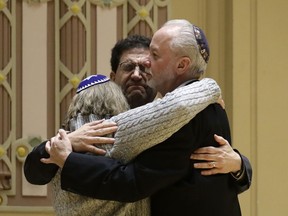 Rabbi Jeffrey Myers, right, of Tree of Life/Or L'Simcha Congregation hugs Rabbi Cheryl Klein, left, of Dor Hadash Congregation and Rabbi Jonathan Perlman during a community gathering held in the aftermath of a deadly shooting at the Tree of Life Synagogue in Pittsburgh, Sunday, Oct. 28, 2018.