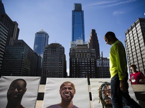 Formerly incarcerated artists Conway Wiltshire moves to pick up his self-portrait at the Mural Arts Philadelphia's press preview of "Portraits of Justice" at the Municipal Services Building in Philadelphia, Wednesday, Oct. 3, 2018. The nation's largest public arts program is launching a large-scale, interactive mural in Philadelphia that focuses on solutions for mass incarceration.