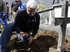 Maritime archaeologist James Delgado inspects debris on the grave site of Julius H. Kroehl before exhuming his body from Amador Cemetery in the Chorrillo neighborhood of Panama City, Thursday, Oct. 11, 2018. The remains of Kroehl, a German-American who was a pioneer on the design of the first submarine to submerge successfully at depth, are being moved to Corozal Cemetery, a cemetery where American veterans are buried.