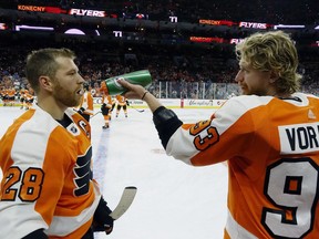 Philadelphia Flyers' captain Claude Giroux, left, gets a drink of water courtesy of Jakub Voracek, right, during pregame skate prior to the start of an NHL hockey game against the San Jose Sharks, Tuesday, Oct. 9, 2018, in Philadelphia.