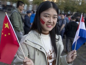 Members of the Chinese community in The Netherlands wait for the arrival of Chinese Premier Li Keqiang in The Hague, Netherlands, Monday, Oct. 15, 2018.