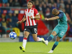 Tottenham midfielder Lucas Lucas soots on goal as PSV's Donyell Malen runs alongside during a Group B Champions League soccer match between PSV Eindhoven and Tottenham Hotspur at the Philips stadium in Eindhoven, Netherlands, Wednesday, Oct. 24, 2018.