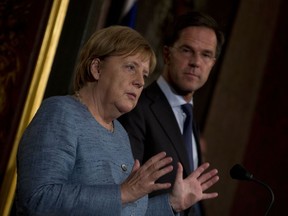 German Chancellor Angela Merkel, left, and Dutch Prime Minister Mark Rutte answer questions after a meeting in The Hague, Netherlands, Wednesday, Oct. 10, 2018. The two leaders met ahead of next week's crucial EU summit in Brussels.
