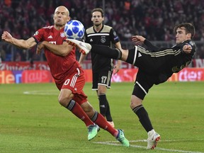 Ajax's Nicolas Tagliafico, right, and Bayern midfielder Arjen Robben, left, vie for the ball during a Group E Champions League soccer match between Bayern Munich and Ajax at the Allianz Arena in Munich, Germany, Tuesday, Oct. 2, 2018.