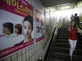 Plastic surgery advertisements are displayed along a staircase at the entrance of a subway station in the Apgujeong-dong area of Gangnam district in Seoul, South Korea, on Saturday, Aug. 3, 2013. The number of tourists visiting South Korea for cosmetic surgery has increased more than fivefold since 2009 to 15,428 last year, the health ministry says.