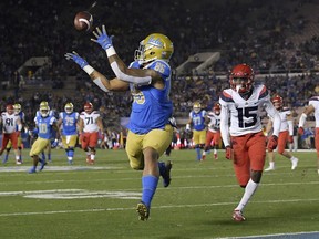 UCLA tight end Devin Asiasi, left, makes a touchdown catch as Arizona cornerback McKenzie Barnes watches during the first half of an NCAA college football game, Saturday, Oct. 20, 2018, in Pasadena, Calif.