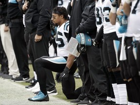 Carolina Panthers strong safety Eric Reid, center, takes a knee during the playing of the national anthem prior to an NFL football game against the Philadelphia Eagles, Sunday, Oct. 21, 2018, in Philadelphia.
