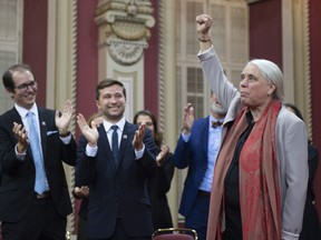 Quebec Solidaire Leader Manon Masse, right raises her fist as she enter for the ceremony after Quebec Solidaire elected members were sworn in as members of the National Assembly, Wednesday, October 17, 2018 at the legislature in Quebec City.