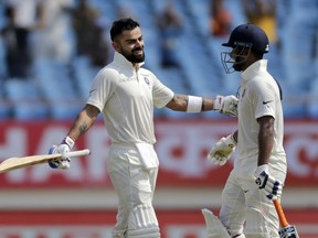 Indian cricketer Virat Kohli, left, celebrates his century with teammate Rishabh Pant during the second day of the first cricket test match between India and West Indies in Rajkot, India, Friday, Oct. 5, 2018.