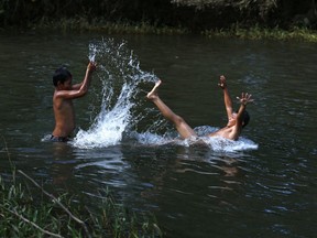 Honduran migrant children play in the Novillero River in Tapanatepec, Mexico, Sunday, Oct. 28, 2018. Thousands of migrants took a break Sunday in in Tapanatepec, on their long journey toward the U.S. border.
