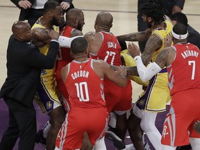 Houston Rockets' Chris Paul, second from left, is held back by Los Angeles Lakers' LeBron James, left, as Paul fights with Lakers' Rajon Rondo, centre obscured, during the second half of an NBA basketball game Saturday, Oct. 20, 2018, in Los Angeles.