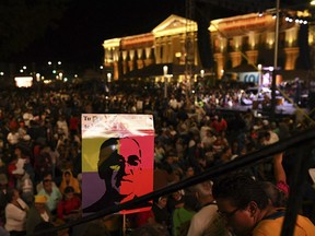 People stay up all night to watch live tv images from the Vatican where El Salvador's martyred Salvadoran Archbishop Oscar Romero is declared a Saint, outside the cathedral where Romero's remains are entombed in San Salvador, El Salvador, early Sunday, Oct. 14, 2018. For many in San Salvador, it was the culmination of a fraught and politicized campaign to have the church formally honor a man who publicly denounced the repression by El Salvador's military dictatorship at the start of the country's 1980-1992 civil war.