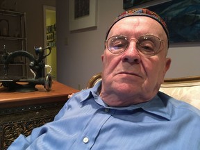 In this Monday, Oct. 29, 2018 photo, Holocaust survivor Judah Samet, 80, sits in his living room in Pittsburgh. Samet survived the infamous Bergen-Belsen concentration camp as a boy, and he was in the parking lot at Tree of Life synagogue Saturday as a gunman rampaged through the halls, killing Samet's fellow congregants.