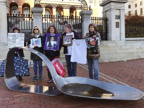 Mothers and relatives who lost loved ones to overdoses stand behind a metal sculpture of a burnt spoon, meant to symbolize opioid use, in front of the Massachusetts Statehouse on Friday, Oct. 26, 2018, in Boston. From left, Mary Peckham, Nancy Didick, Laurie Smith, Lynn Wencuf and Joan Smith. Organizers of The Spoon Movement said they planned to present the sculpture to state Attorney General Maura Healey to recognize her advocacy for leadership efforts in fighting the opioid scourge.