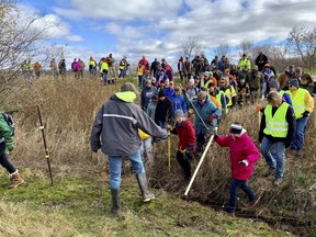 Volunteers cross a creek and barbed wire near Barron, Wis., Tuesday, Oct. 23, 2018, on their way to a ground search for 13-year-old Jayme Closs who was discovered missing Oct. 15 after her parents were found fatally shot at their home. The search for Closs was expanded Tuesday, with as many as 2,000 volunteers expected to take part in a search of the area.