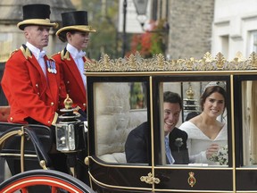 Princess Eugenie of York, right, and Jack Brooksbank smile as they travel from St George's Chapel to Windsor Castle after their wedding at St George's Chapel, Windsor Castle, near London, England, Friday, Oct 12, 2018.