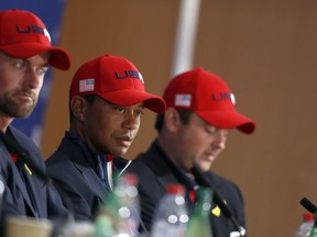 US players Webb Simpson, left, Tiger Woods and Patrick Reed, right, attend the press conference of the losing team after Europe won the 2018 Ryder Cup golf tournament at Le Golf National in Saint Quentin-en-Yvelines, outside Paris, France, Sunday, Sept. 30, 2018.