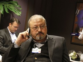 FILE - In this Jan. 29, 2011, file photo, Saudi Arabian journalist Jamal Khashoggi speaks on his cellphone at the World Economic Forum in Davos, Switzerland. The Washington Post said Wednesday, Oct. 3, 2018, it was concerned for the safety of Khashoggi, a columnist for the newspaper, after he apparently went missing after going to the Saudi Consulate in Istanbul.