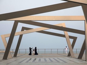 Women wearing chadors walk past an art installation on the corniche promenade in Dhahran, Saudi Arabia, on Oct. 4, 2018. MUST CREDIT: Bloomberg photo by Simon Dawson.